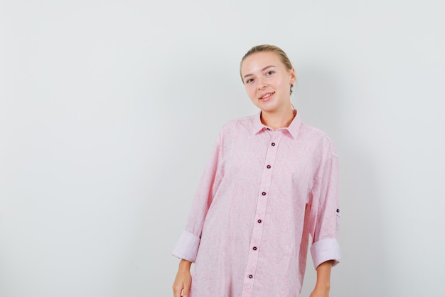 Free photo young woman looking in pink shirt and looking joyful