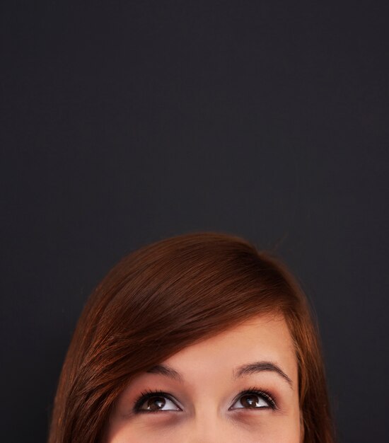 Young woman looking up at blackboard