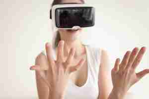 Free photo young woman looks on own hands through vr glasses