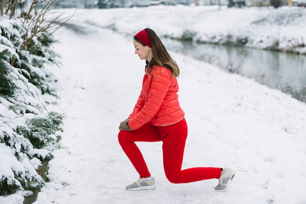 Young woman lunging in winter park