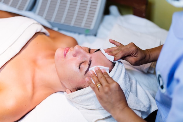 Young woman lying on cosmetologist's table during rejuvenation procedure