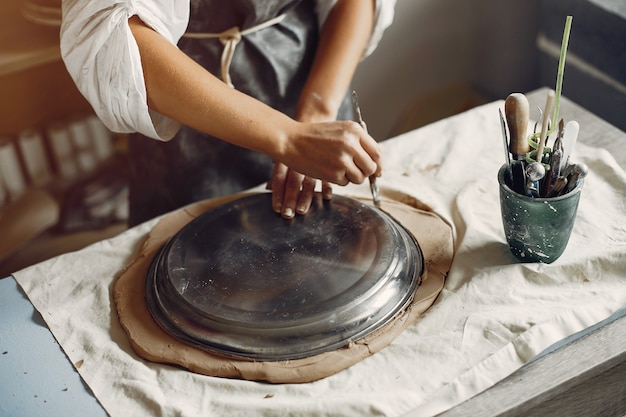 Young woman makes pottery in workshop