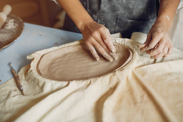 Free photo young woman makes pottery in workshop