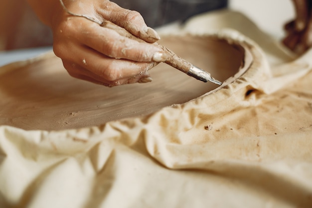 Free photo young woman makes pottery in workshop