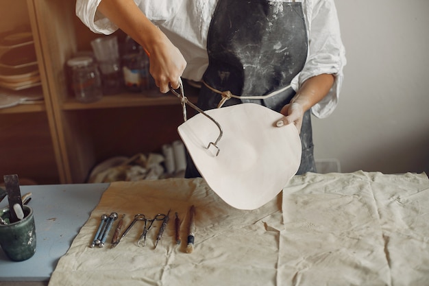 Young woman makes pottery in workshop