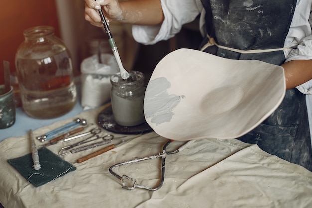 Free photo young woman makes pottery in workshop