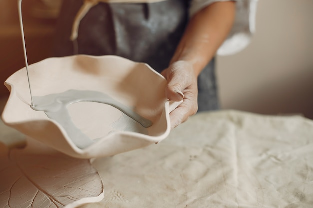 Young woman makes pottery in workshop