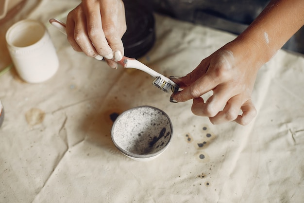 Free photo young woman makes pottery in workshop