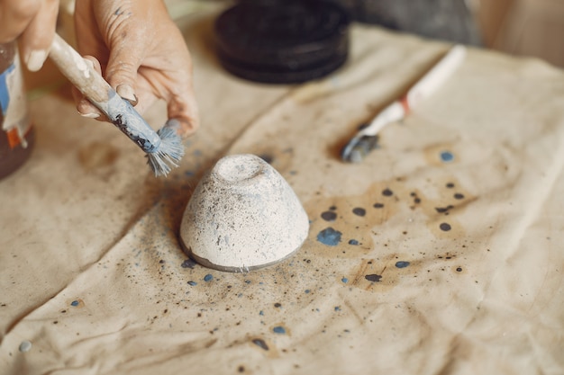 Free photo young woman makes pottery in workshop