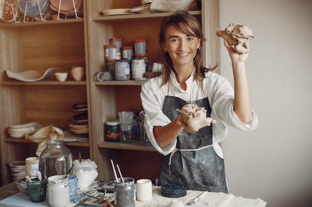 Free photo young woman makes pottery in workshop