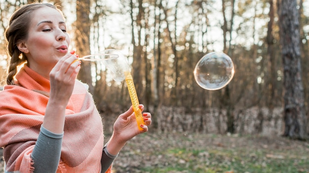 Young woman making bubbles