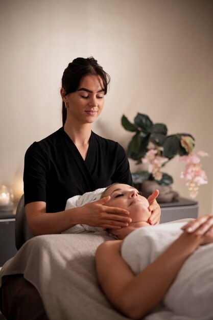 Young woman massaging her client's face