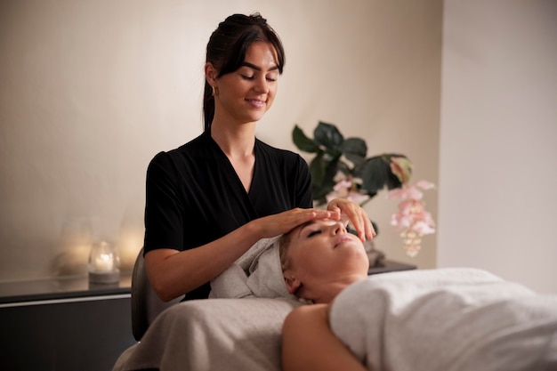 Young woman massaging her client's face