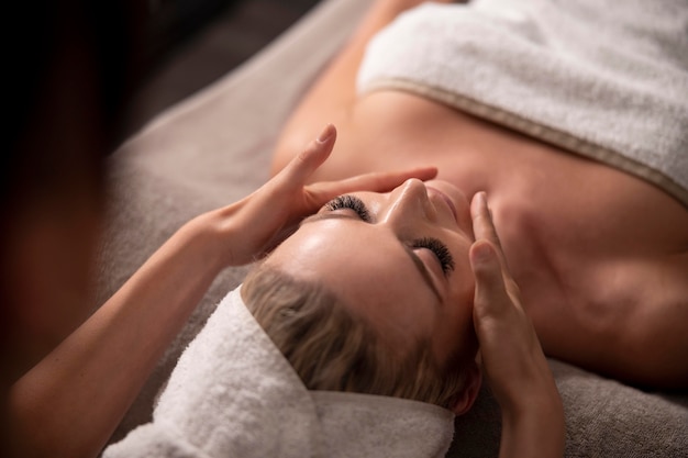 Young woman massaging her client's face