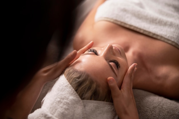 Young woman massaging her client's face