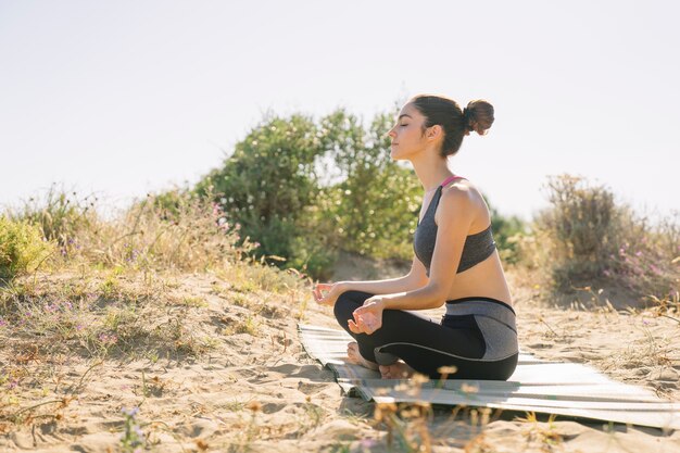 Young woman meditating at the beach