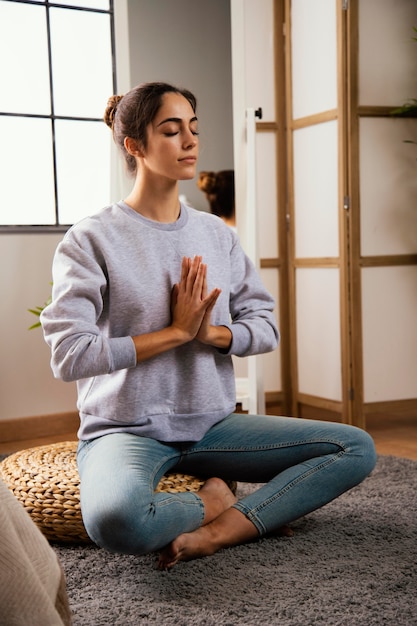 Free photo young woman meditating at home