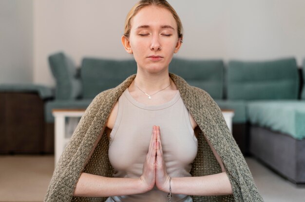 Young woman meditating at home