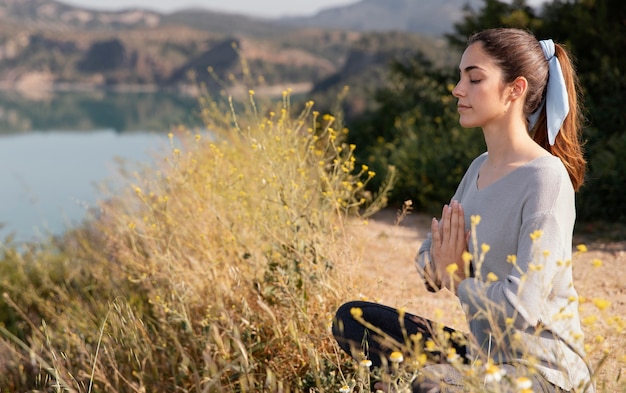 Free photo young woman meditating in nature