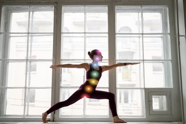 Young woman meditating with chakras on her body