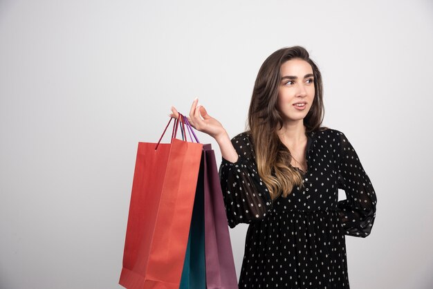 Young woman model carrying a lot of shopping bags 