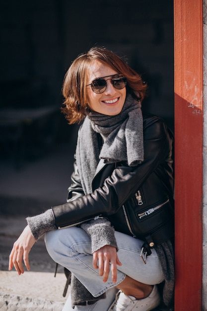 Free photo young woman model in leather jacket outside the street