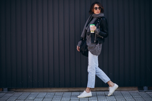 Young woman model in leather jacket outside the street