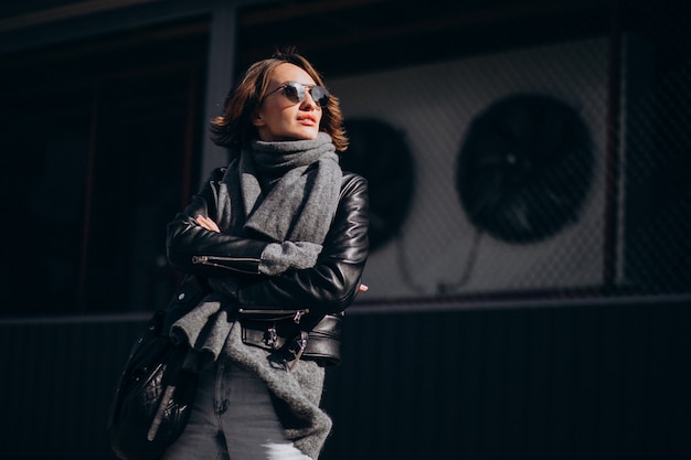 Free photo young woman model in leather jacket outside the street