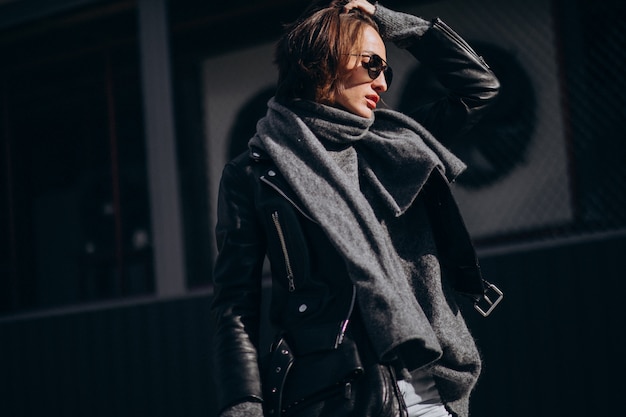 Free photo young woman model in leather jacket outside the street