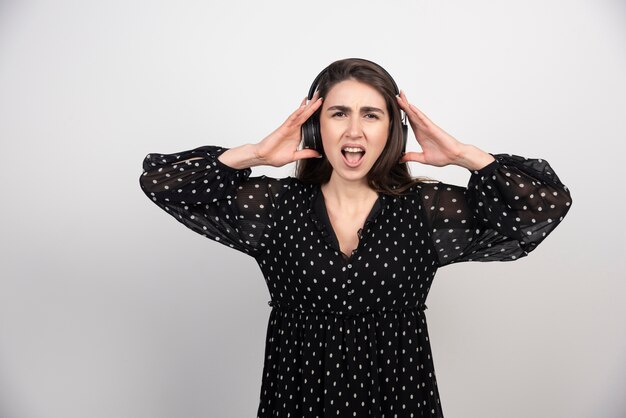 Young woman model listening music in headphones 