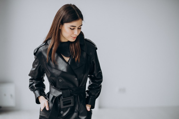 Young woman model wearing long black leather coat