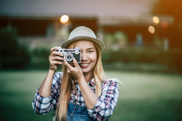 Free photo young woman model with retro film camera