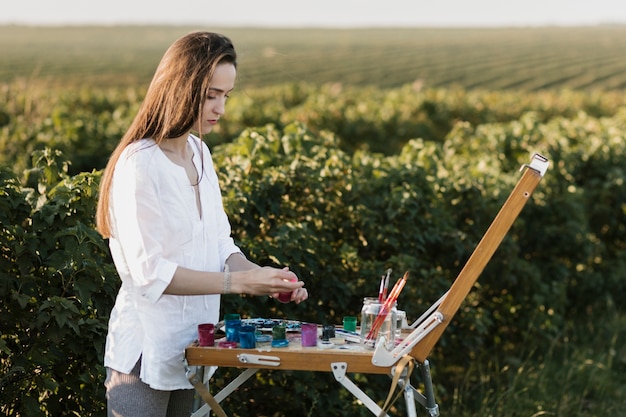 Free photo young woman painting an artwork