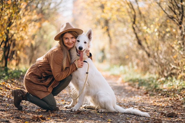 Young woman in park with her white dog