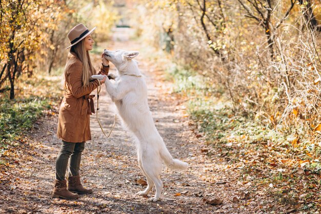 Young woman in park with her white dog