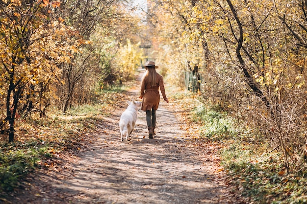 Free photo young woman in park with her white dog