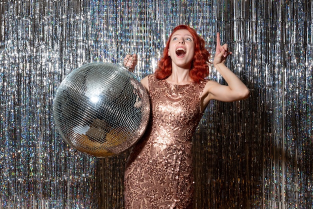 young woman in party with disco ball on bright curtains