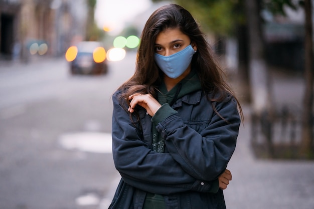 Young woman, person in protective medical sterile mask at empty street