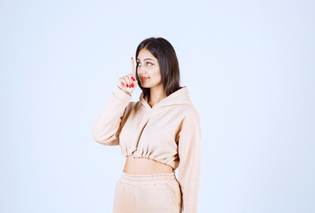 Young woman in a pink hoodie asking for silence