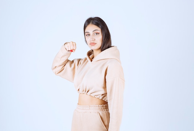 Free Photo young woman in a pink hoodie feeling strong and powerful