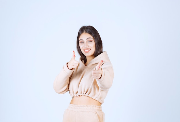 Young woman in a pink hoodie showing good hand sign