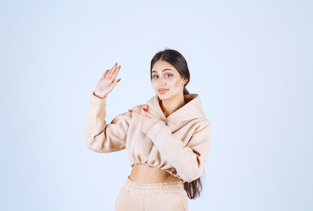 Young woman in a pink hoodie stopping an undesirable thing