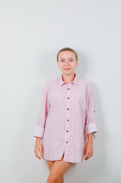 Free photo young woman in pink shirt posing while standing and looking beautiful