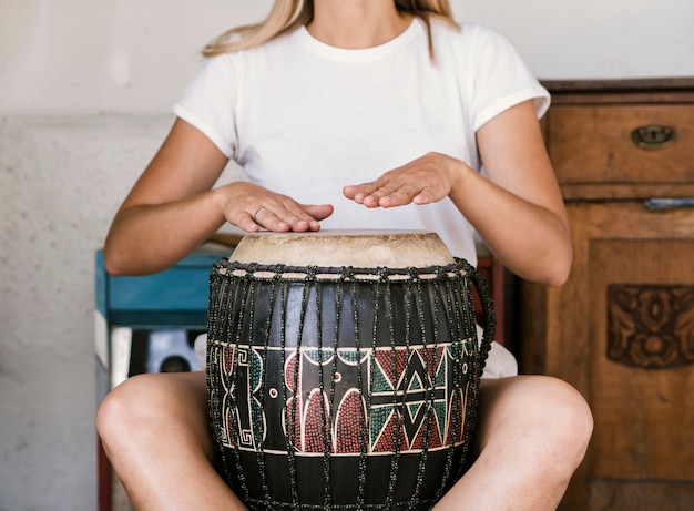 Free Photo young woman playing conga drum