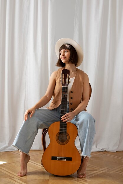 Young woman playing guitar indoors