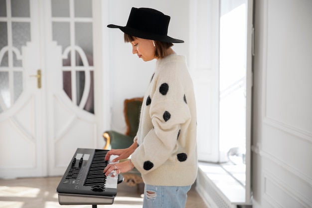 Free photo young woman playing the piano indoors