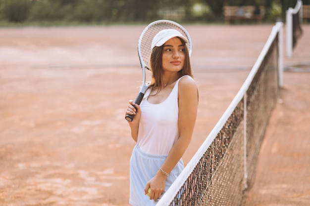 Free photo young woman playing tennis at the court