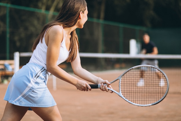 Young woman playing tennis at the court