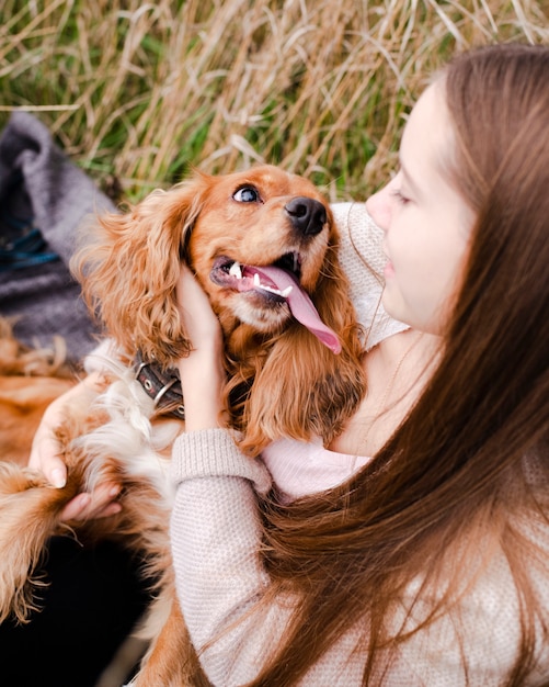 Free Photo young woman playing with her puppy