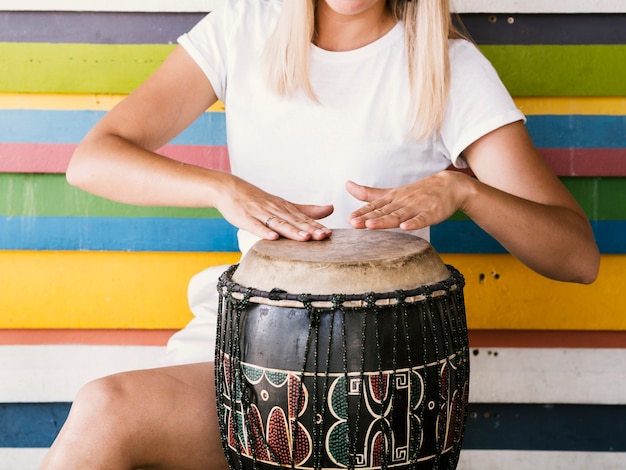 Free photo young woman playing yuker drum